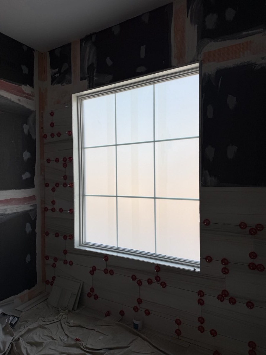 Window with frosted privacy film in a room still under construction